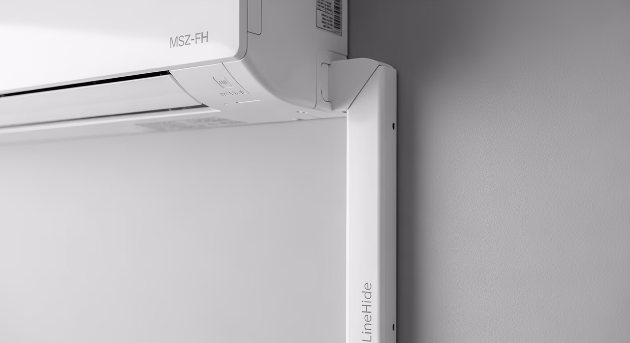 Close-up of wall-mounted Mitsubishi indoor head with concealed LineHide lineset cover painted to match